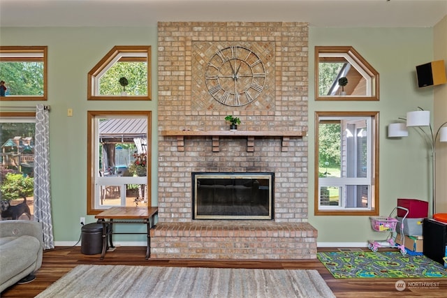 living room featuring hardwood / wood-style flooring and a brick fireplace