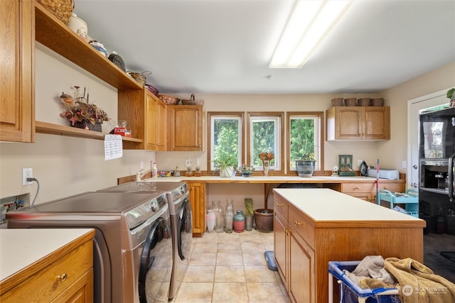 kitchen featuring a center island, washing machine and clothes dryer, and light tile patterned floors