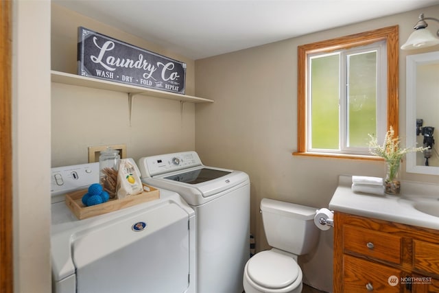 bathroom featuring vanity, independent washer and dryer, and toilet