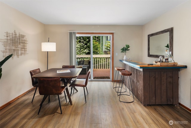 dining room featuring light wood-type flooring and bar area