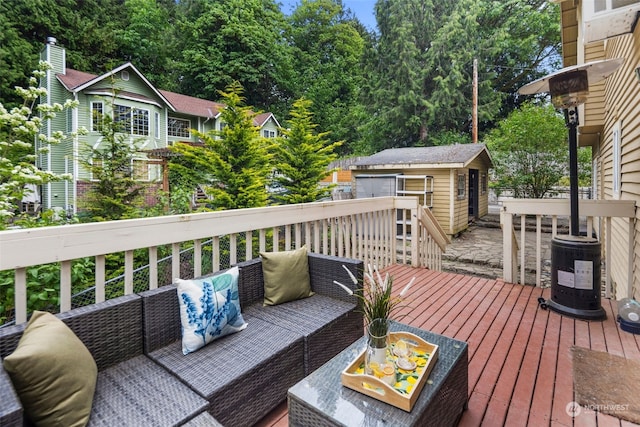 wooden terrace featuring an outdoor living space and an outbuilding