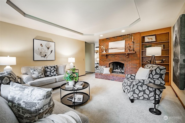 carpeted living area with a brick fireplace, recessed lighting, built in features, and a raised ceiling