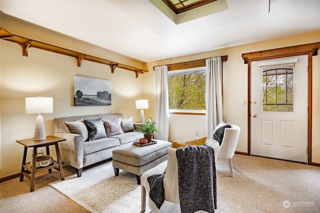 living room with light colored carpet, beamed ceiling, and baseboards