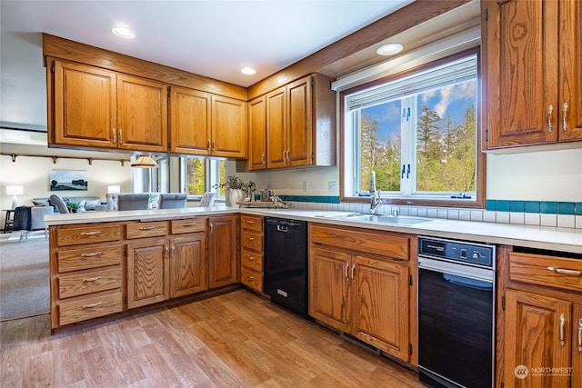 kitchen featuring a sink, dishwasher, a healthy amount of sunlight, and light countertops