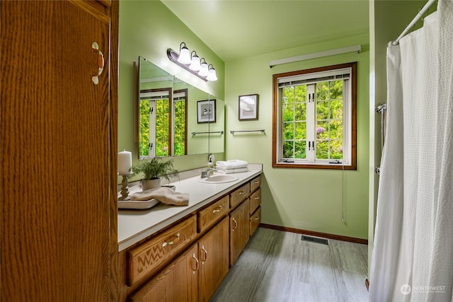 full bathroom featuring visible vents, a shower with shower curtain, vanity, wood finished floors, and baseboards