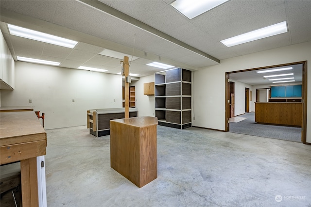 home office featuring a paneled ceiling and concrete floors