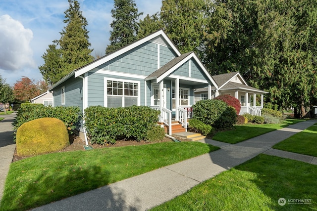 bungalow-style home with covered porch and a front yard