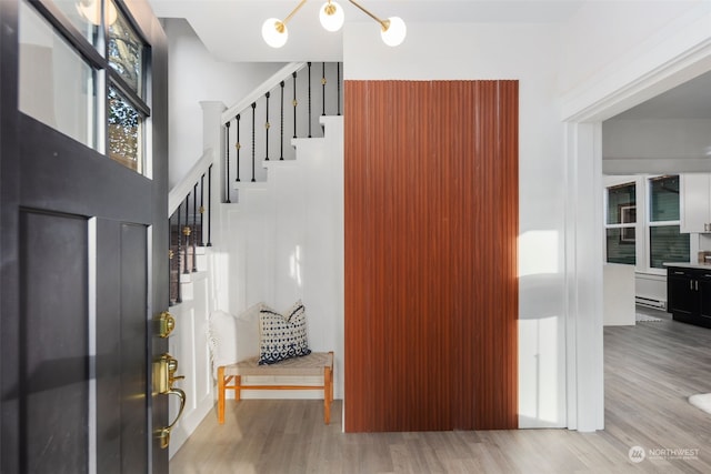 entryway with a chandelier, light hardwood / wood-style flooring, and a baseboard heating unit