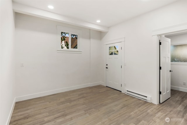 foyer featuring baseboard heating and light wood-type flooring