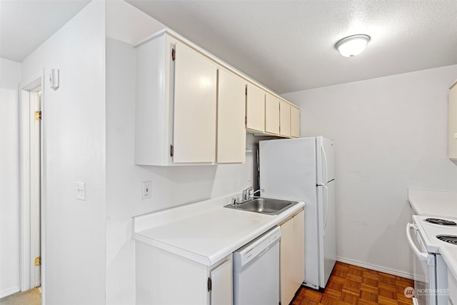 kitchen with sink, white cabinets, a textured ceiling, and white appliances