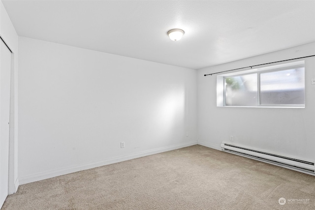 carpeted empty room featuring baseboard heating