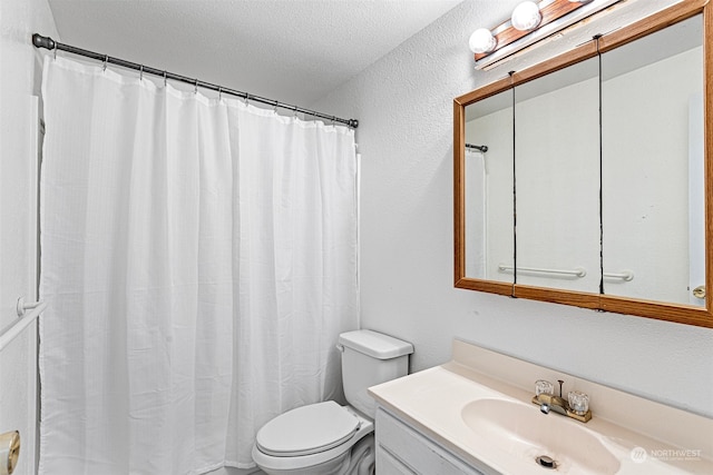 bathroom with vanity, toilet, a textured ceiling, and a shower with shower curtain