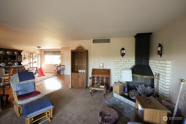 carpeted living room with a wood stove