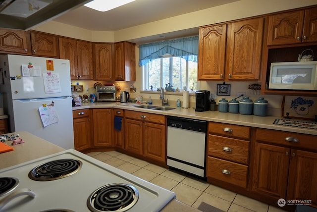 kitchen featuring white appliances, light tile patterned floors, and sink