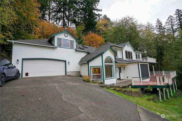 view of property with a deck, a balcony, and a garage