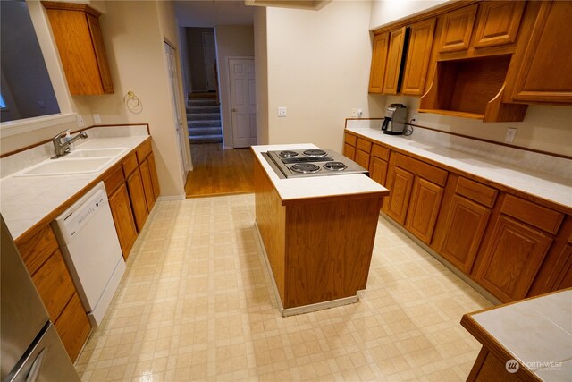 kitchen with sink, white dishwasher, a center island, and stainless steel gas stovetop