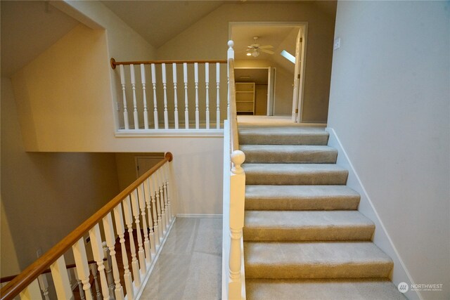 stairway featuring vaulted ceiling, carpet flooring, and ceiling fan