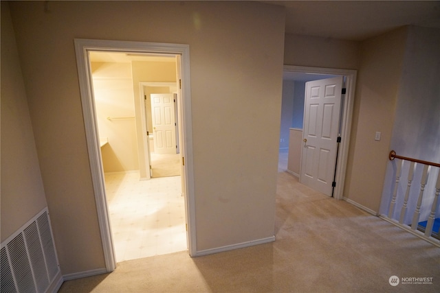 hallway featuring light carpet