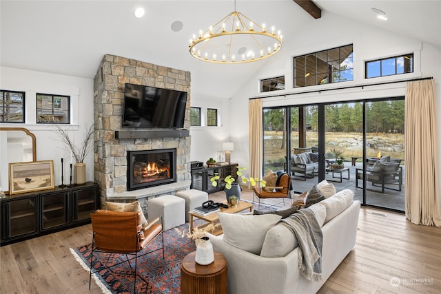 living room with beam ceiling, an inviting chandelier, high vaulted ceiling, light hardwood / wood-style floors, and a fireplace