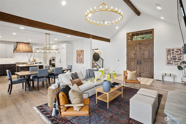 living room with a chandelier, lofted ceiling with beams, and light hardwood / wood-style floors