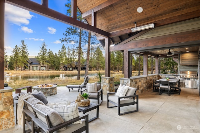 view of patio / terrace featuring a water view, ceiling fan, and an outdoor living space with a fire pit