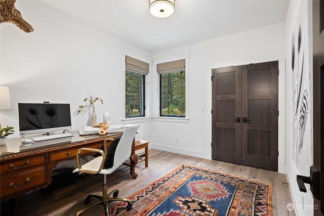 home office with light hardwood / wood-style flooring