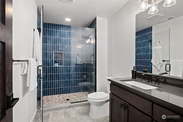 bathroom featuring tile patterned flooring, vanity, an enclosed shower, and toilet