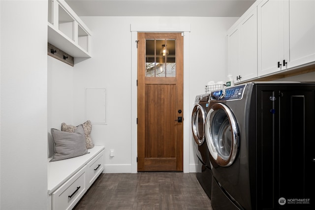 laundry area featuring washer and clothes dryer, dark hardwood / wood-style flooring, and cabinets