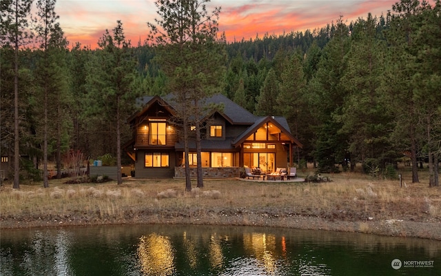 back house at dusk with a water view