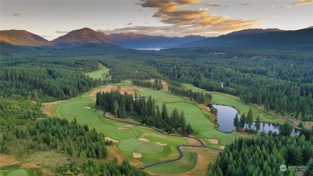 aerial view at dusk featuring a water and mountain view