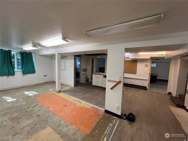 basement featuring dark hardwood / wood-style flooring and a textured ceiling