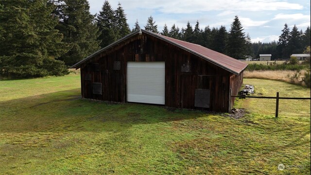 view of outbuilding with a garage and a lawn