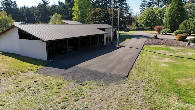 exterior space with a carport and a lawn