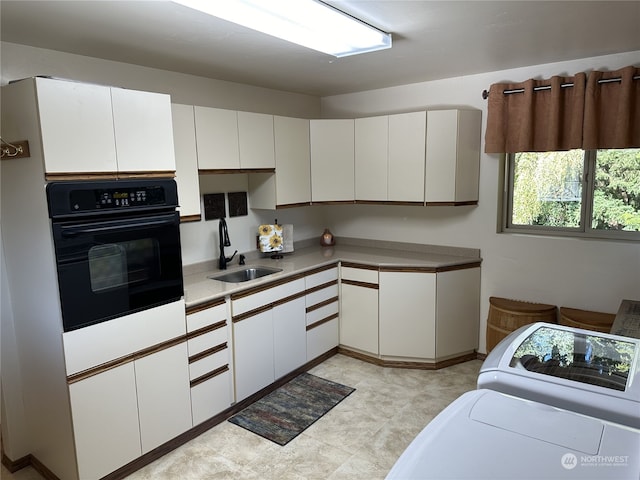 kitchen with white cabinetry, oven, and sink