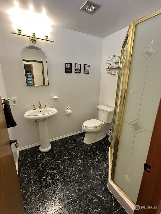 bathroom with toilet and a shower with shower door