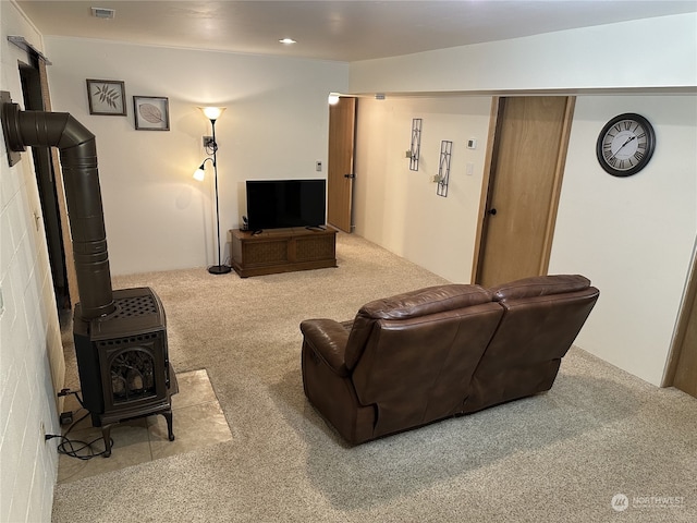 carpeted living room featuring a wood stove