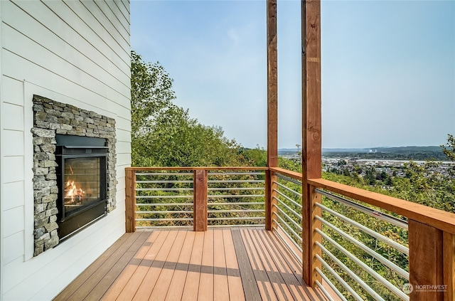 wooden deck featuring an outdoor stone fireplace