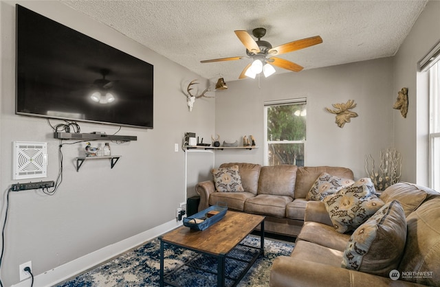 living room featuring a textured ceiling and ceiling fan