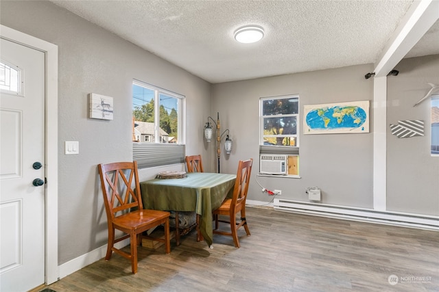 dining area featuring a textured ceiling, a baseboard heating unit, and hardwood / wood-style flooring