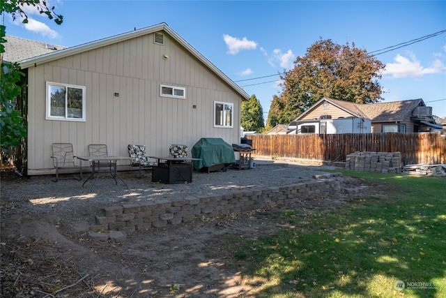 rear view of property featuring a yard and a patio area