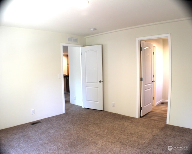 unfurnished bedroom with dark carpet