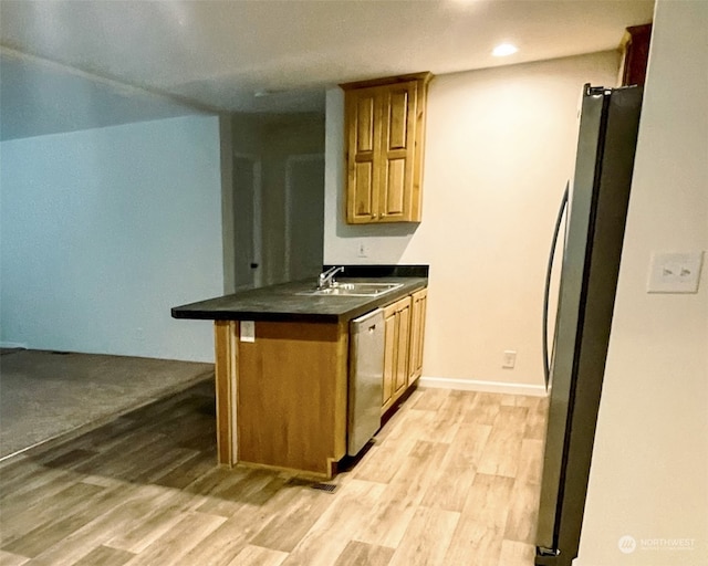 kitchen featuring appliances with stainless steel finishes, kitchen peninsula, sink, and light wood-type flooring