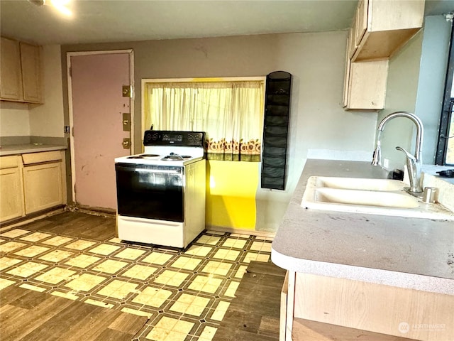 kitchen with light hardwood / wood-style flooring, light brown cabinetry, sink, and electric range