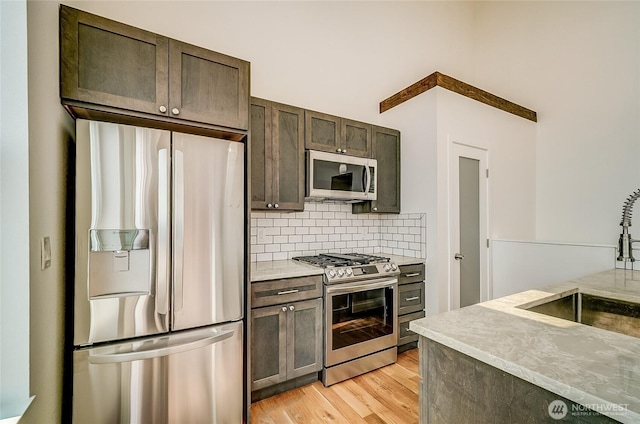 1823 Sam Benn Ln, Aberdeen, WA 98520 - kitchen with stainless steel appliances, a sink, dark brown cabinets, backsplash, and light wood finished floors