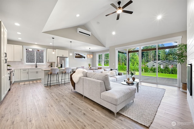 living room with an AC wall unit, high vaulted ceiling, light hardwood / wood-style flooring, and ceiling fan