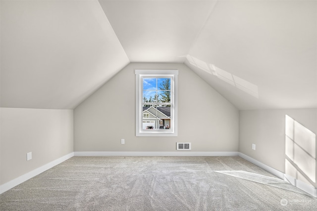 additional living space with vaulted ceiling and light colored carpet