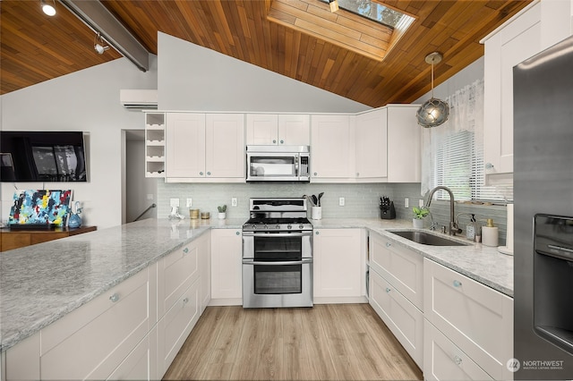 kitchen with white cabinets, sink, pendant lighting, light hardwood / wood-style floors, and stainless steel appliances