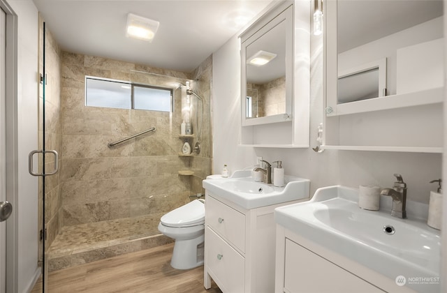 bathroom featuring vanity, toilet, hardwood / wood-style flooring, and a shower with shower door