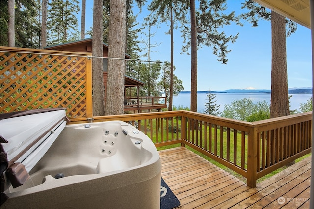 wooden terrace with a water view and a hot tub