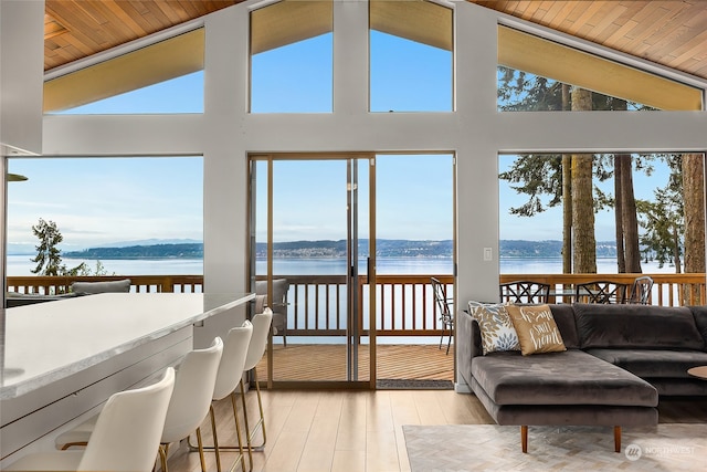 sunroom / solarium featuring vaulted ceiling, a water view, and wooden ceiling